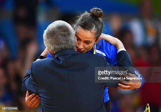Gold medalist Majlinda Kelmendi of Kosovo is embraced by IOC President Thomas Bach during the medal ceremony for the Women's -52kg Judoon Day 2 of...