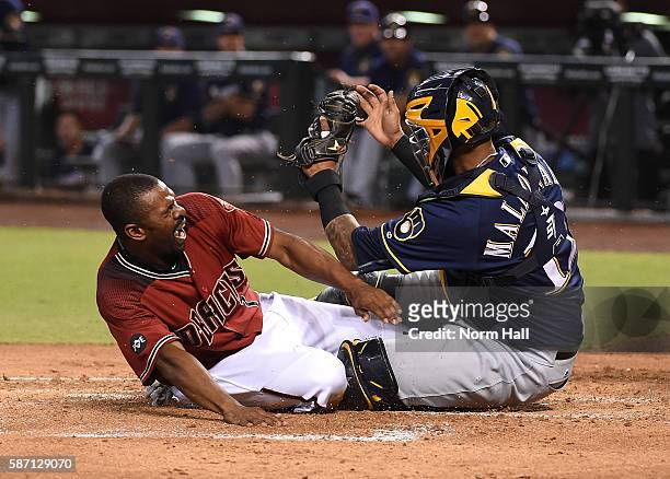 Michael Bourn of the Arizona Diamondbacks is tagged out at home plate by Martin Maldonado of the Milwaukee Brewers during the first inning at Chase...