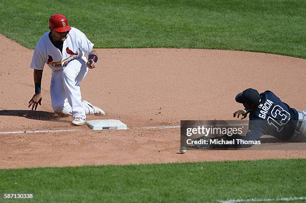 Yadier Molina of the St. Louis Cardinals slides safely into third base as Adonis Garcia of the Atlanta Braves is not able to make the tag during a...