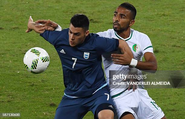 Argentina player Cristian Pavon vies for the ball with Algeria player Houari Ferhani during the Rio 2016 Olympic Games men's First Round Group D...