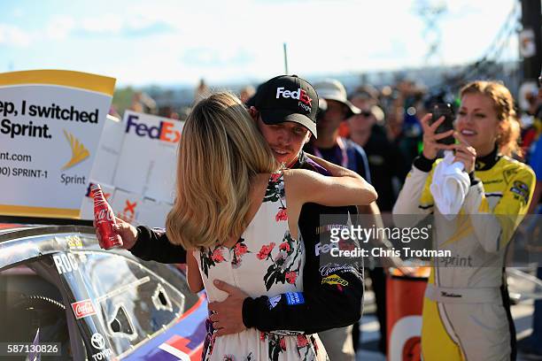 Denny Hamlin, driver of the FedEx Freight Toyota, celebrates in victory lane with girlfriend Jordan Fish after winning the NASCAR Sprint Cup Series...