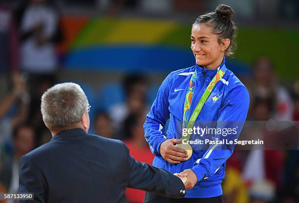 Gold medalist Majlinda Kelmendi of Kosovo is presented her medal by IOC President Thomas Bach during the medal ceremony for the Women's -52kg Judoon...