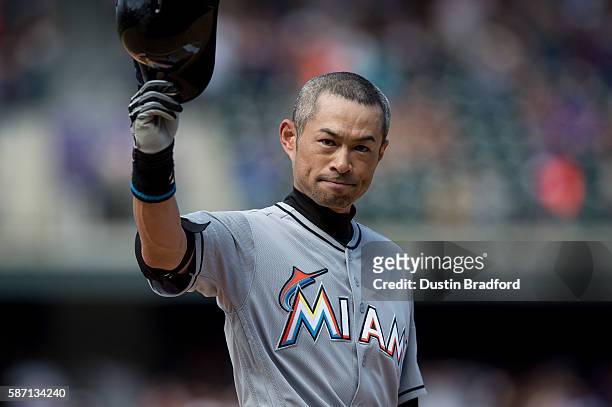 Ichiro Suzuki of the Miami Marlins tips his hat to the crowd after hitting a seventh inning triple against the Colorado Rockies for the 3,000th hit...