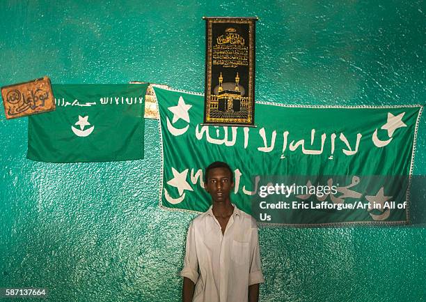 Sufi young man worshipper in front of islamic flags, harari region, harar, Ethiopia on March 4, 2016 in Harar, Ethiopia.