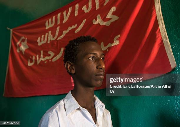 Sufi man worshipper in front of islamic red flag, harari region, harar, Ethiopia on March 4, 2016 in Harar, Ethiopia.