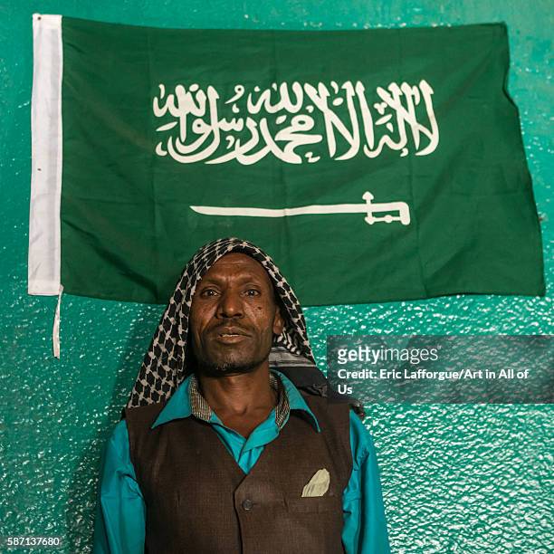 Sufi imam in front of islamic green flag, harari region, harar, Ethiopia on March 4, 2016 in Harar, Ethiopia.