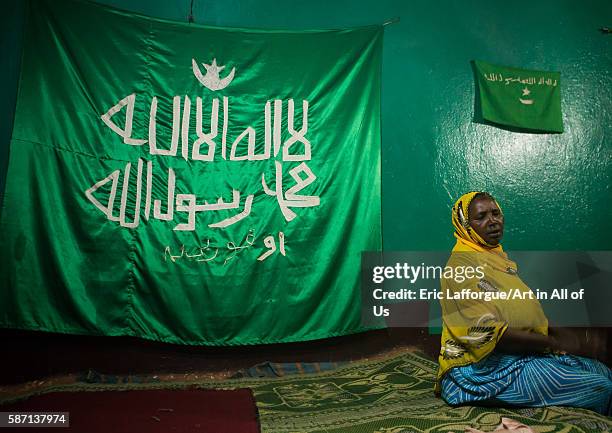 Sufi woman worshipper in front of islamic flag, harari region, harar, Ethiopia on March 4, 2016 in Harar, Ethiopia.