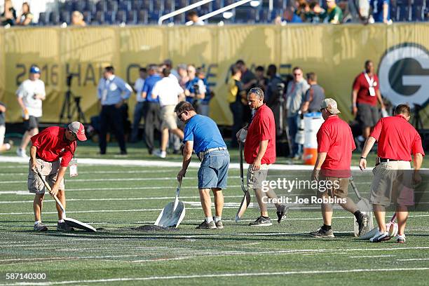 Crews work on the field prior to the NFL Hall of Fame Game between the Green Bay Packers and Indianapolis Colts at Tom Benson Hall of Fame Stadium on...