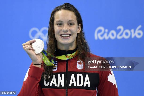 Canada's Penny Oleksiak celebrates on the podium after she won silver in the Women's 100m Butterfly Final during the swimming event at the Rio 2016...