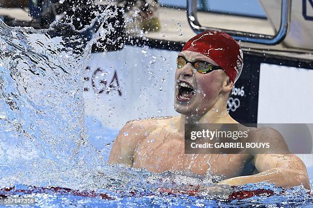Britain's Adam Peaty celebrates after he broke the World Record in the Men's 100m Breaststroke Final during the swimming event at the Rio 2016...