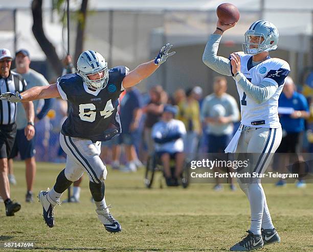 Dallas Cowboys quarterback Jameill Showers gets a pass off under pressure from defensive end Zach Wood during the Blue vs. White scrimmage on Sunday,...