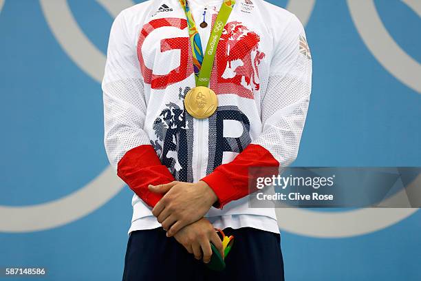 Gold medalist Adam Peaty of Great Britain poses on the podium during the medal ceremony for the Men's 100m Breaststroke Final on Day 2 of the Rio...