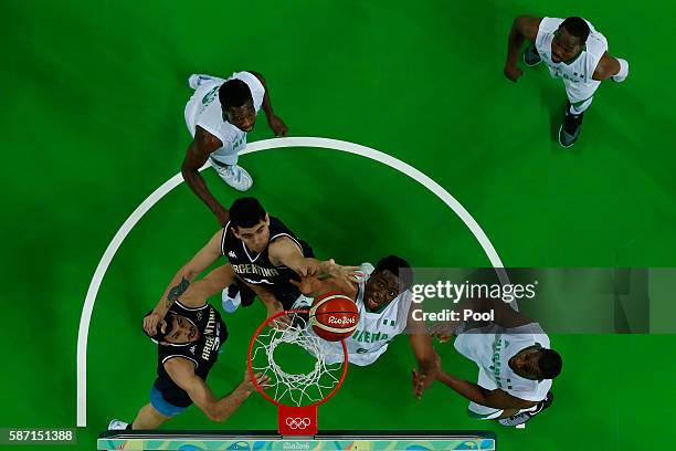 Ike Diogu of Nigeria shoots against Gabriel Deck and Roberto Acuna of Argentina during a Men's preliminary round basketball game between Nigeria and...