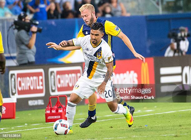 DeLaGarza of Los Angeles Galaxy battles Mike Grella of New York Red Bulls during Los Angeles Galaxy's MLS match against the New York Red Bulls at the...