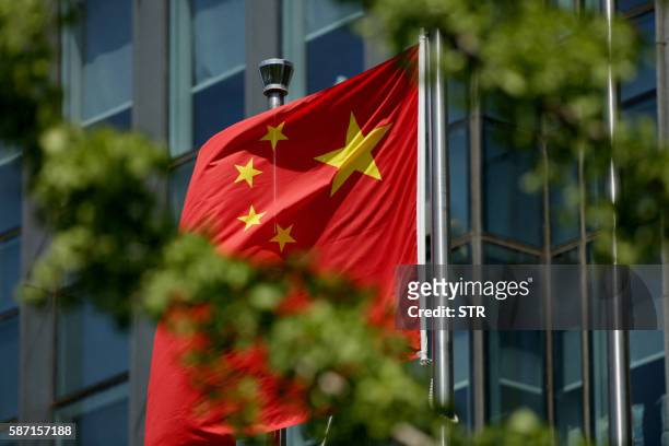 The Chinese national flag is seen on a flagpole in Beijing on August 8, 2016. - Most of the five stars on the Chinese flags being used at medal...