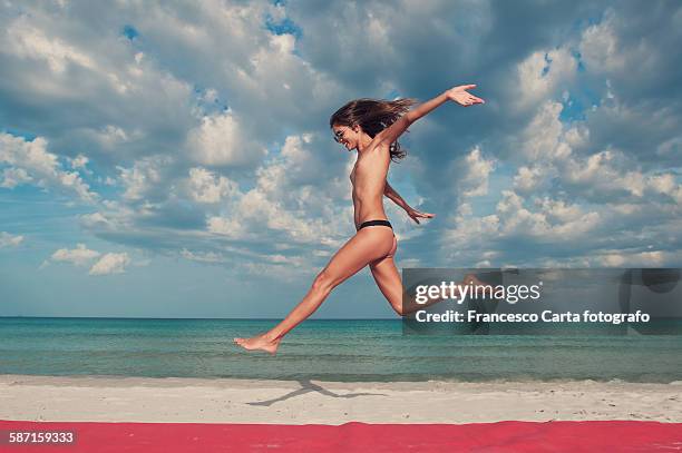 woman jumping on the beach - sin camisa fotografías e imágenes de stock