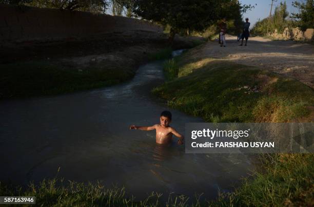 In this photograph taken on August 7 an Afghan child swims in a canal on the outskirts of Mazar-i-Sharif.