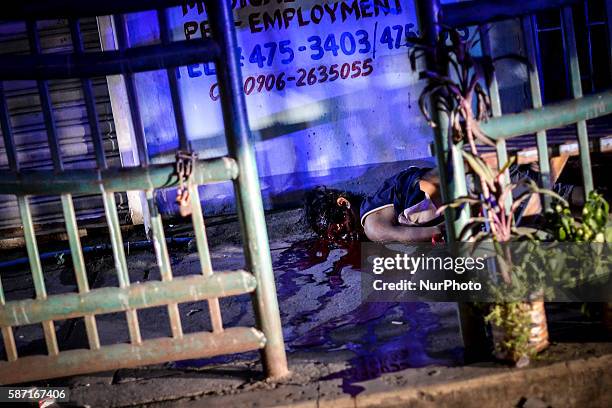 Image depicts graphic content.) The corpse of a suspected drug addict lies on a street after he was shot dead by unidentified gunmen in Quezon city,...