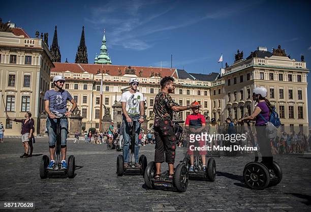 Tourists ride Segways on a street in the city centre in front of the Prague Castle on August 7, 2016 in Prague, Czech Republic. Prague city...