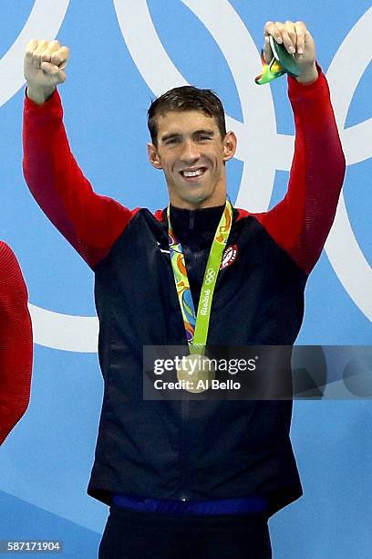Michael Phelps of the United States celebrates in the medal ceremony after winning the gold medal in the Men's 4 x 100m Freestyle Relay on Day 2 of...