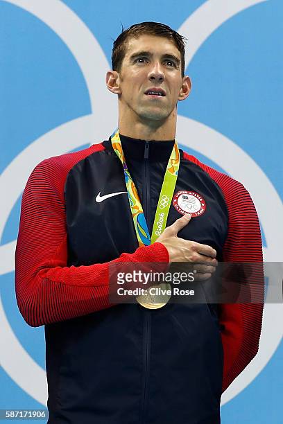 Michael Phelps of the United States celebrates in the medal ceremony after winning the gold medal in the Men's 4 x 100m Freestyle Relay on Day 2 of...