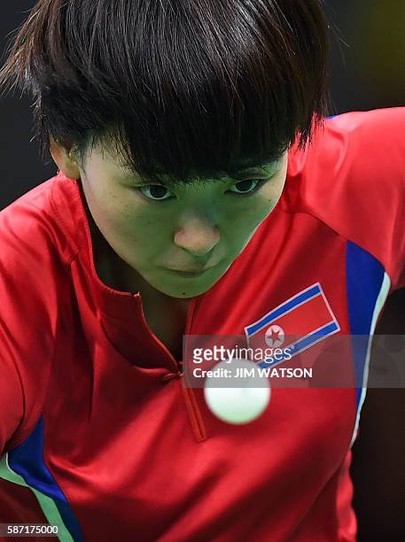 North Korea's Ri Myong Sun eyes the ball in her women's singles qualification round table tennis match at the Riocentro venue during the Rio 2016...