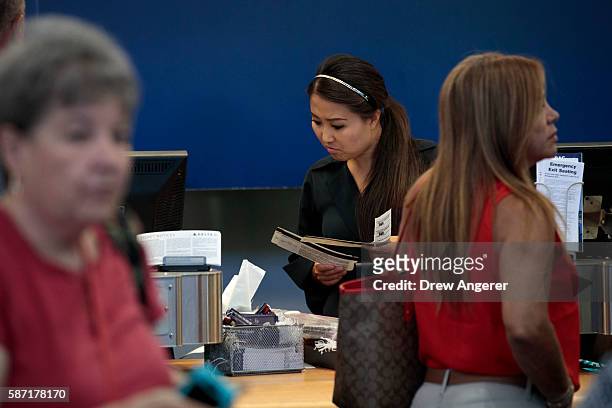 Delta employee looks at airline tickets at the Delta check-in counter at LaGuardia Airport , August 8, 2016 in the Queens borough of New York City....