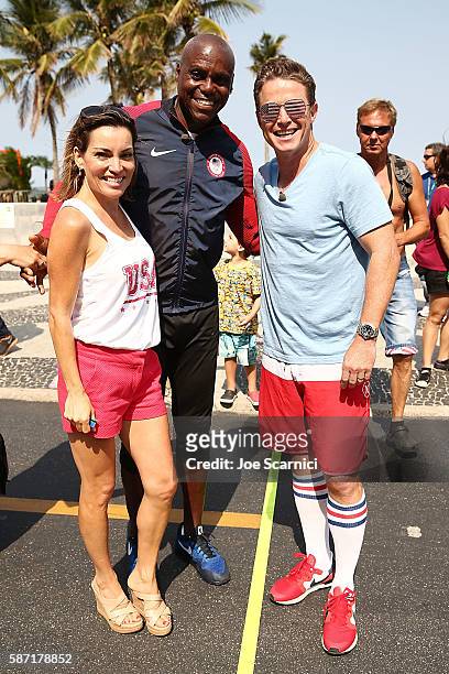 Kit Hoover, Billy Bush & Olympic Legend Carl Lewis pose for a photo on the finish line after a Speed-Walking Race for Ages at Copacabana beach on...