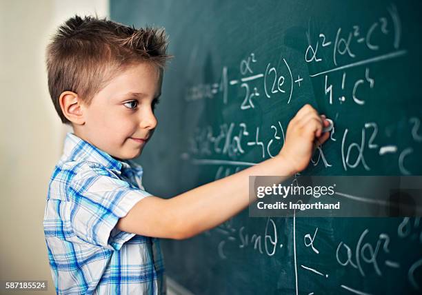 cute little boy solving difficult mathematical problems - mathematician stockfoto's en -beelden