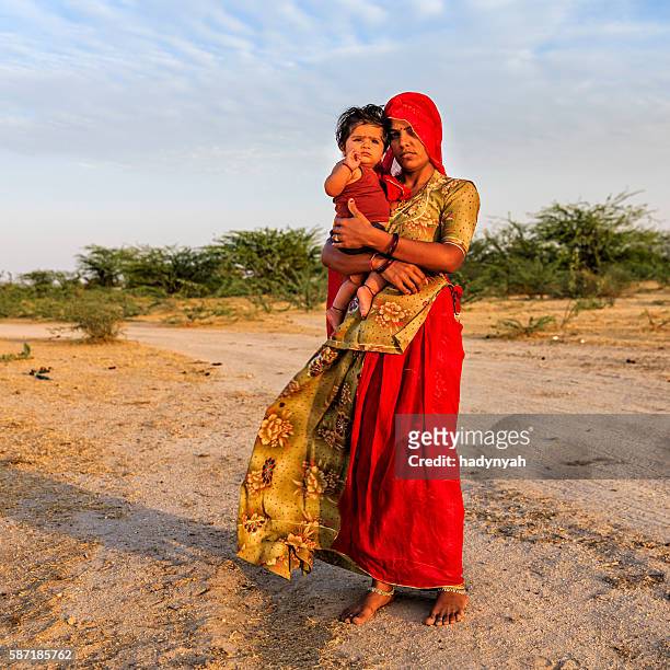 young indian woman holding her little baby, india - rajasthani women stock pictures, royalty-free photos & images