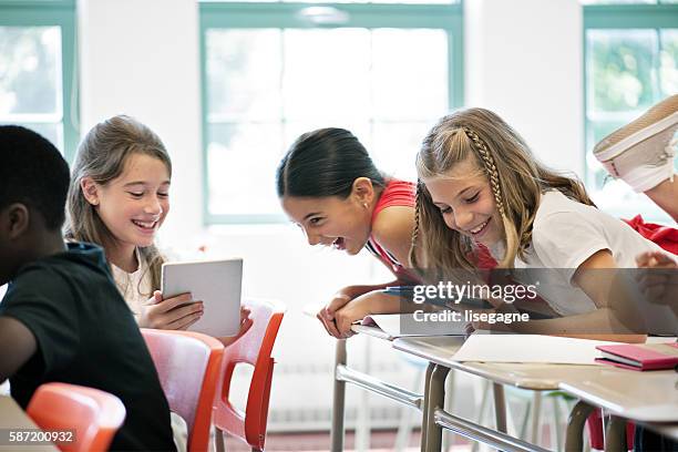 school kids in class using a digital tablet - naughty in class stock pictures, royalty-free photos & images