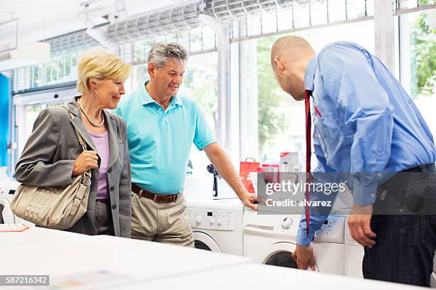 senior couple buying a washing machine - buying washing machine stock pictures, royalty-free photos & images