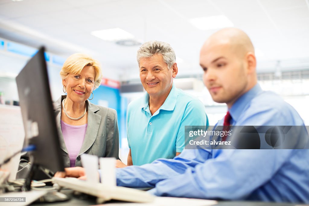 Senior couple at appliance store paying for purchase