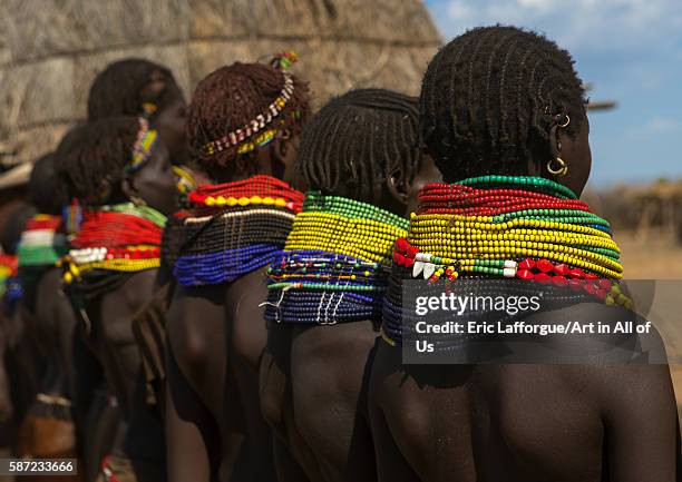 Nyangatom tribe women with huge necklaces in a line, omo valley, kangate, Ethiopia on March 15, 2016 in Kangate, Ethiopia.