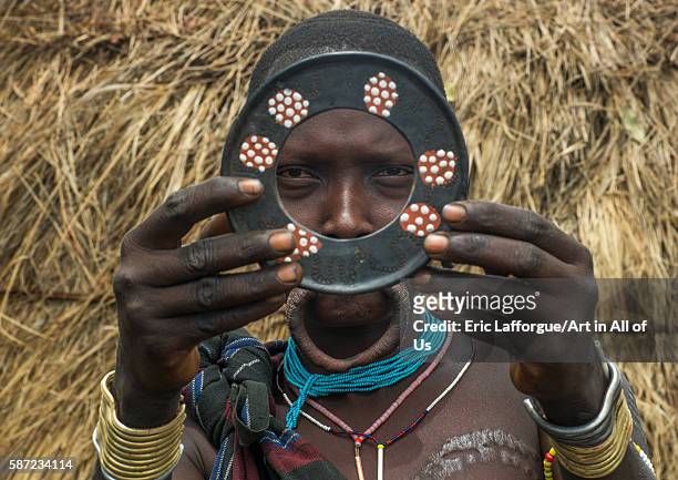 Amursi tribeswoman holding a traditional lip-plate, omo valley, mago park, Ethiopia on March 18, 2016 in Mago Park, Ethiopia.