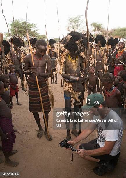 European tourist showing the screen of his camera in dassanech tribe, omo valley, omorate, Ethiopia on March 20, 2016 in Omorate, Ethiopia.