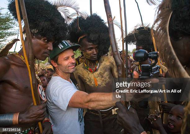 European tourist showing the screen of his camera in dassanech tribe, omo valley, omorate, Ethiopia on March 20, 2016 in Omorate, Ethiopia.