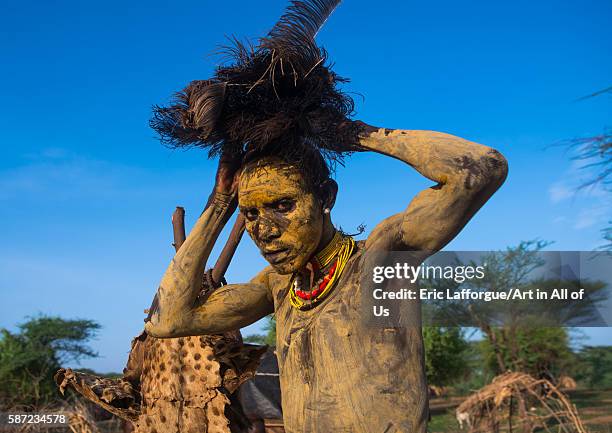 Dassanech man dressing with an ostrich feathers headwear for dimi ceremony to celebrate circumcision of the teenagers, omo valley, omorate, Ethiopia...