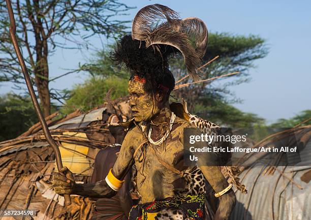 Dassanech man with leopard skin and ostrich feathers headwear during dimi ceremony to celebrate circumcision of teenagers, omo valley, omorate,...