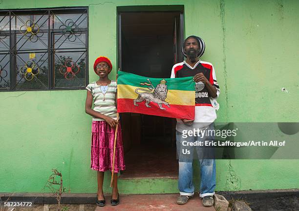Rastafari girl called kizzy holding a flag with her father, oromo, shashamane, Ethiopia on March 23, 2016 in Shashamane