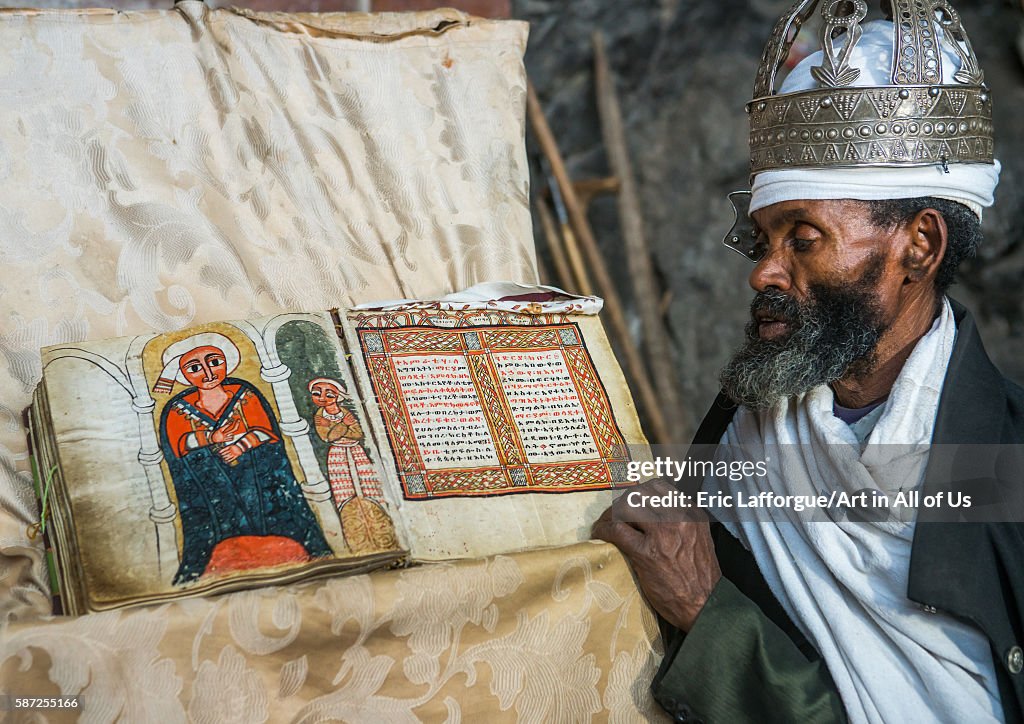 Ethiopian orthodox priest with an old bible in nakuto lab rock church, Amhara region, Lalibela, Ethiopia