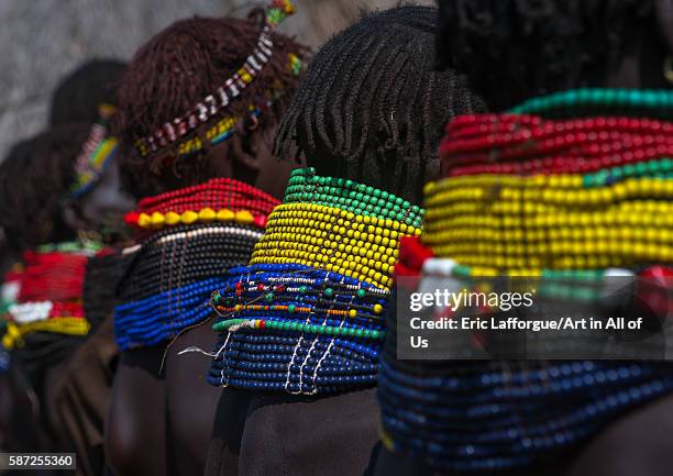 Nyangatom tribe women with huge necklaces in a line, omo valley, kangate, Ethiopia on March 15, 2016 in Kangate, Ethiopia.