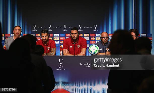 In this handout image provided by UEFA, Players Vitolo and Vicente Iborra with Head Coach Jorge Sampaoli talk to the media during the Sevilla Press...