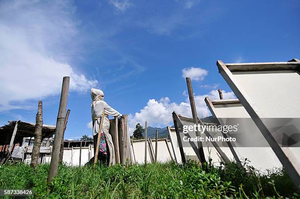 Shova Gurung, 20 yrs. Old, studying in grade 12, helps her mother to set dry Nepalese traditional handmade lokta paper in the sun at Bhumisthal,...