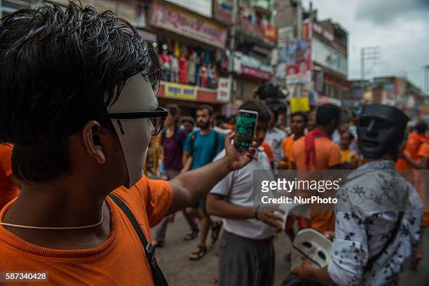 Kanwariya waits at queue at Kashi Vishwanath Temple after fill his pots with holy water from the river Ganga, for the betterment of his family and...