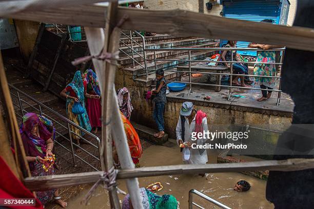 Kanwariya waits at queue at Kashi Vishwanath Temple after fill his pots with holy water from the river Ganga, for the betterment of his family and...