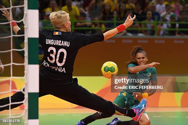Romania's goalkeeper Paula Ungureanu tries to stop a shot by Brazil's right wing Alexandra Martinez during the women's preliminaries Group A handball...