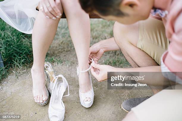 man tying womans shoes - kneeling feet stock pictures, royalty-free photos & images