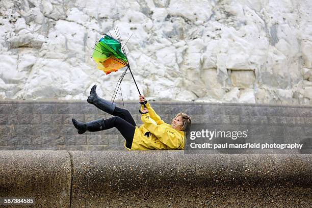 lady struggling with broken umbrella - broken heel stock-fotos und bilder