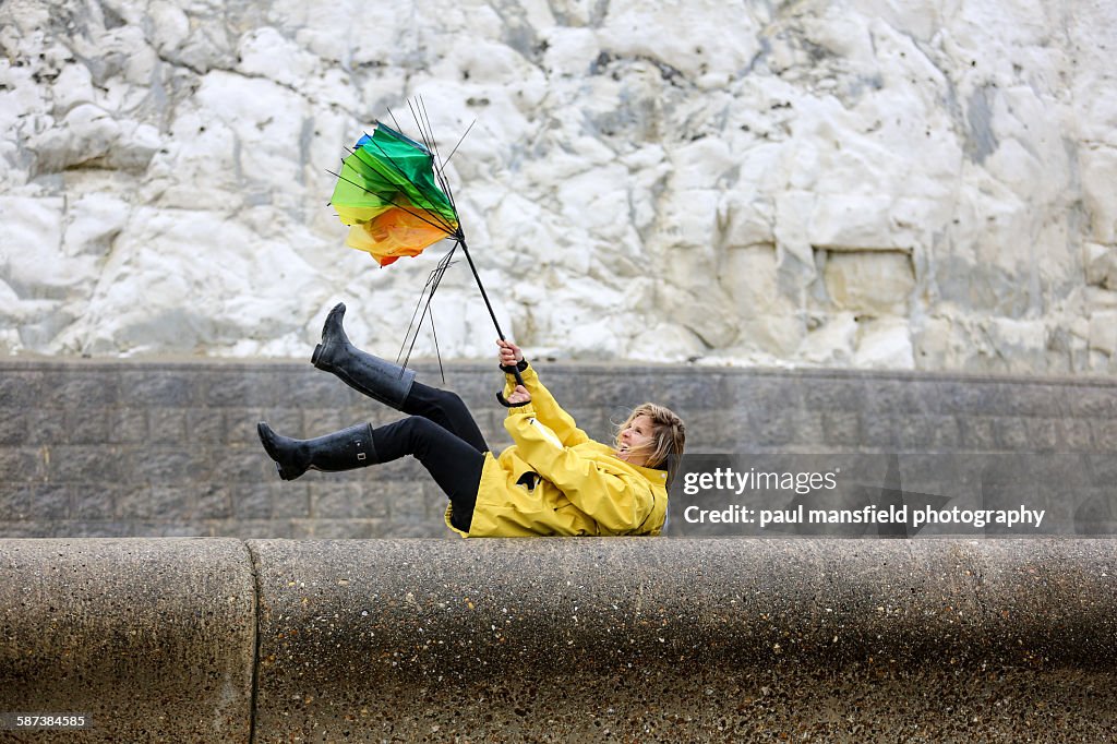 Lady struggling with broken umbrella